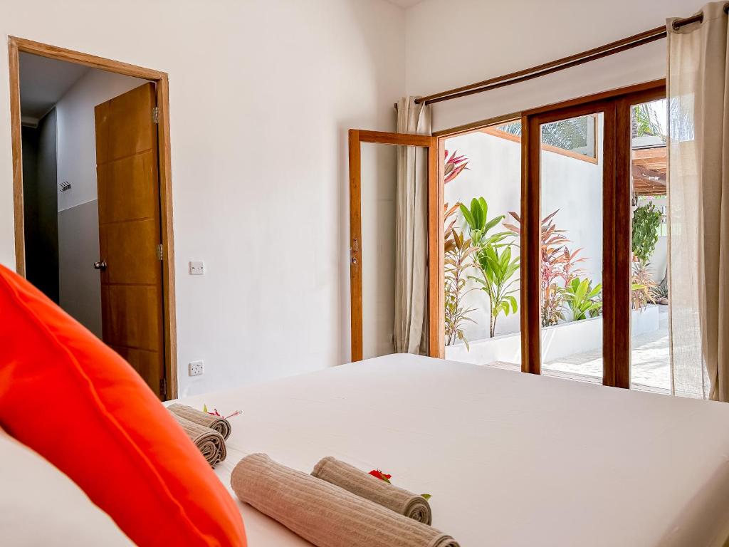 a bedroom with a bed and a large window at Villa Kudì Maldives Guest House Thulusdhoo in Thulusdhoo