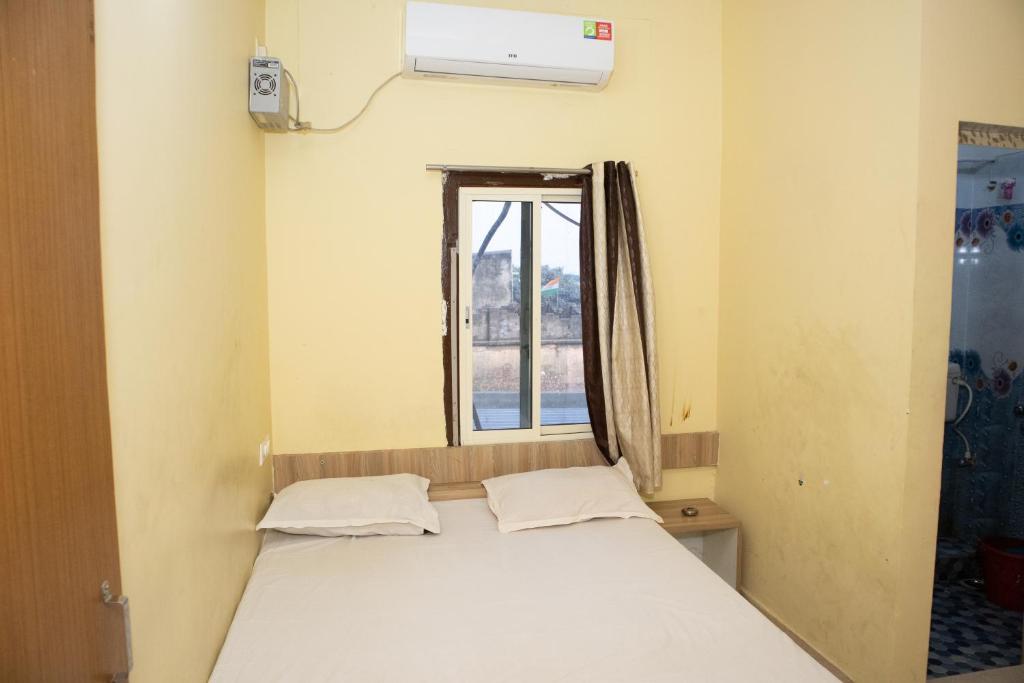 a bed in a room with a window at Ganesh Residency in Cuttack