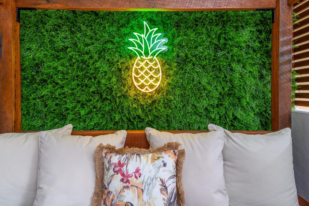 a green wall with a pineapple painted on it at Luxury Living In The Heart Of Town, King Bed, 2 Pools, Free WIFI And Undercover Parking in Port Douglas