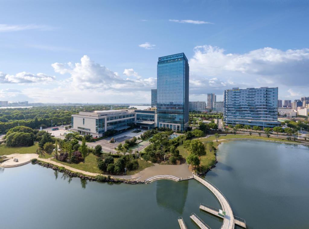 uma vista aérea de uma cidade com uma grande massa de água em Wyndham Grand Suzhou Fenhu em Xintazhen