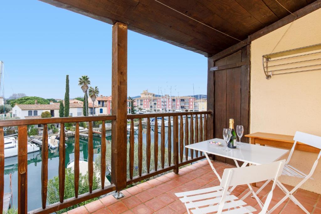 balkon ze stołem i krzesłami oraz widokiem na wodę w obiekcie Grimaud 4 vents YourHostHelper w mieście Grimaud