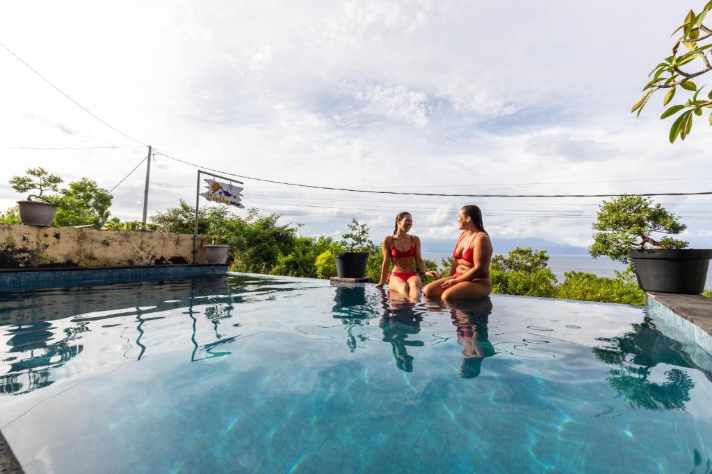 zwei Frauen in einem Schwimmbad in der Unterkunft D' Artha Cottage in Nusa Penida
