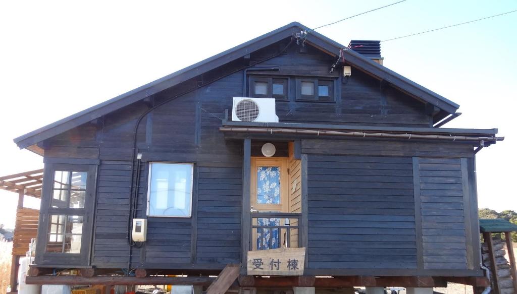 una casita azul con puerta y ventanas en Koinami en Shima