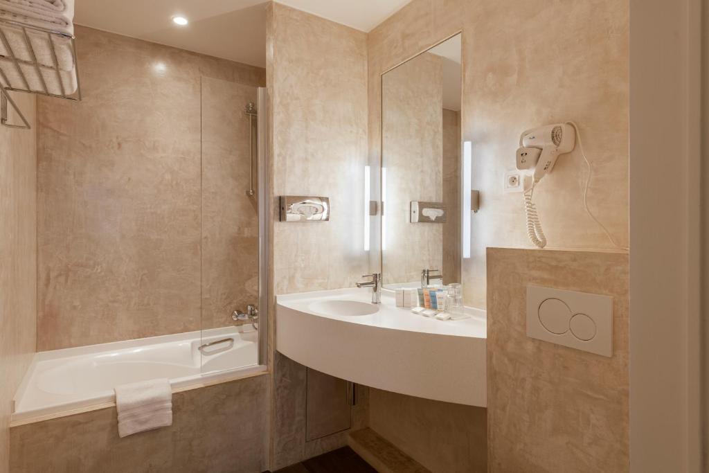 a bathroom with a sink and a bath tub at Dukes' Academie Brugge - by Dukes' Hotel Collection in Bruges