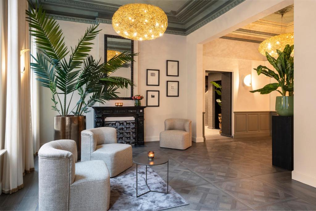 a living room with two chairs and a fireplace at Dukes' Academie Brugge - by Dukes' Hotel Collection in Bruges