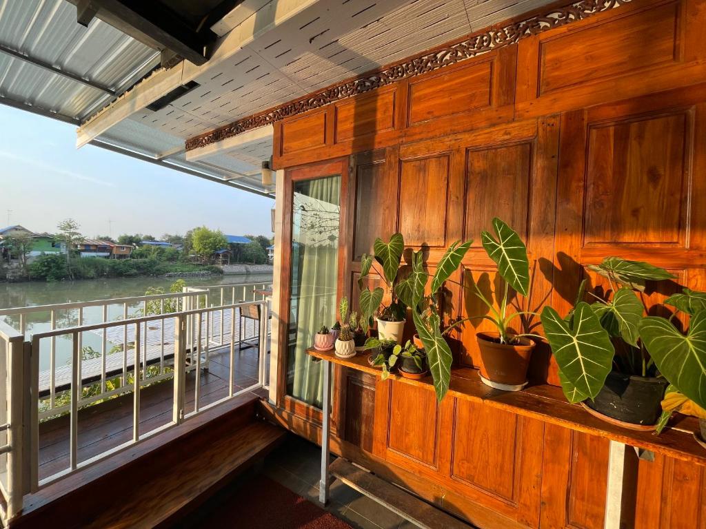 a balcony with potted plants on a wooden wall at Baan Keang Chon Ayutthaya บ้านเคียงชล อยุธยา in Phra Nakhon Si Ayutthaya