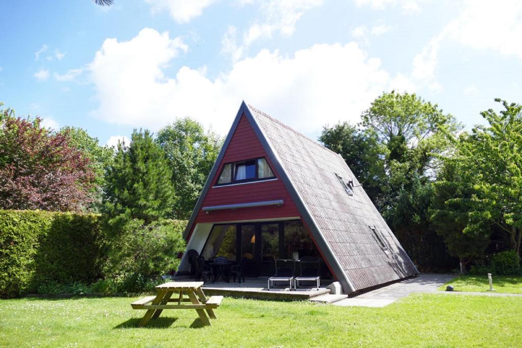 eine kleine Hütte mit einem Picknicktisch im Gras in der Unterkunft Zeltdachhaus mit W-LAN - sehr strandnah in Damp