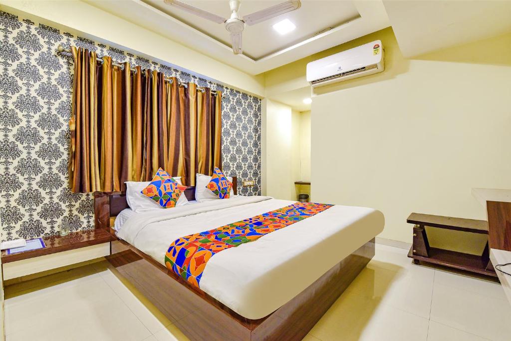 um quarto com uma cama e uma janela em FabExpress Red Apple em Ahmedabad