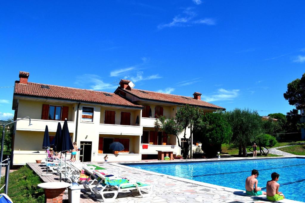 a villa with a swimming pool in front of a house at Residenza Benini in Bardolino