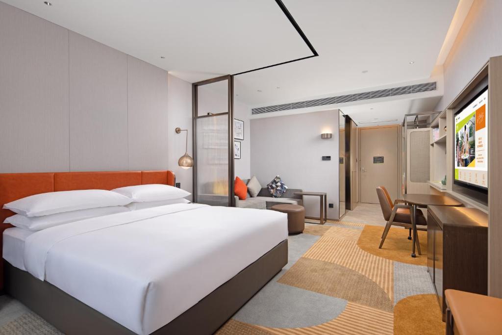 una camera da letto con un letto grande e un soggiorno di Home2 Suites By Hilton Shenzhen Dalang a Shenzhen