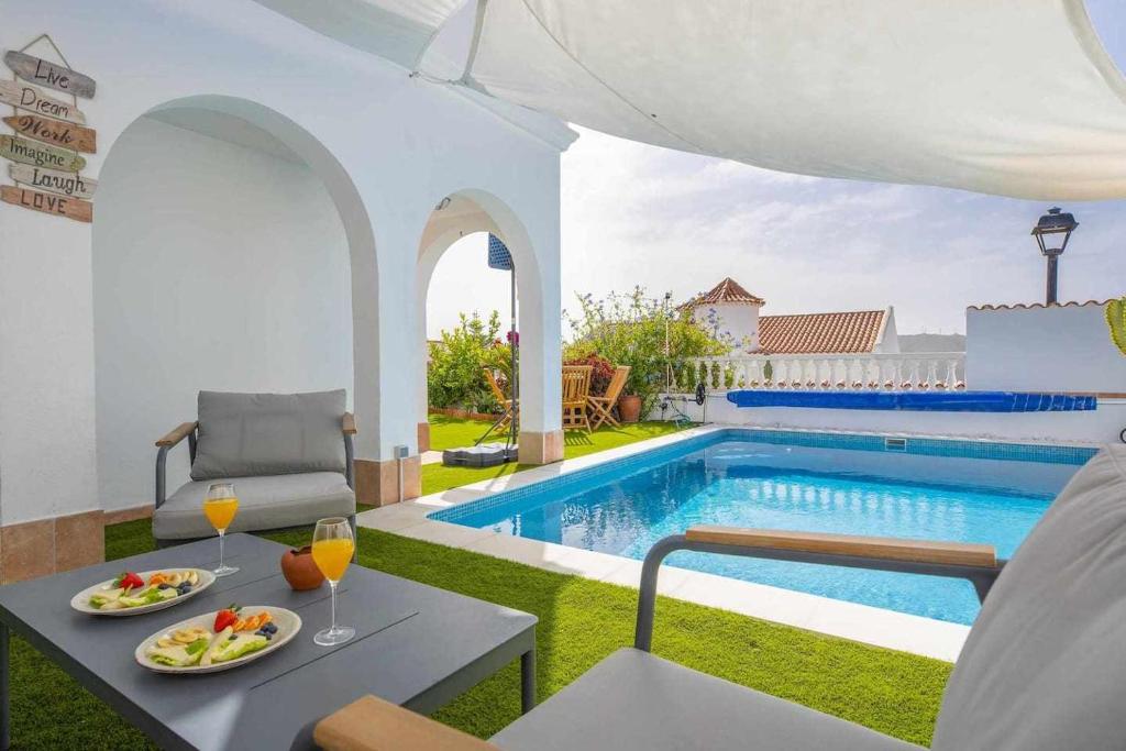 uma villa com uma piscina e uma mesa com comida e bebidas em Family Chayofa by W Tenerife em Chayofa