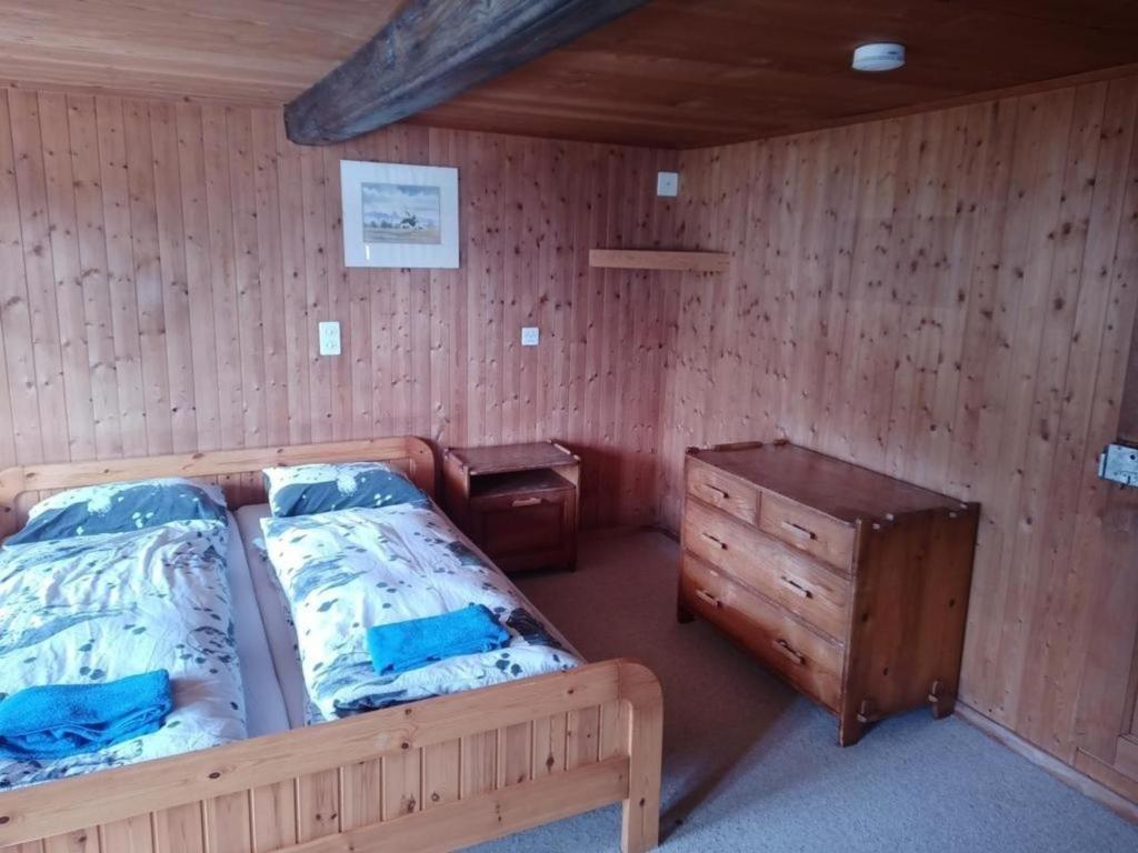ein Schlafzimmer mit einem Bett und einer Kommode darin in der Unterkunft Antikes Ferienhaus in Trub