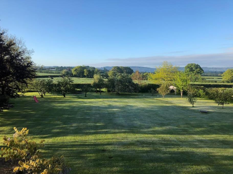 a large green field with trees in the distance at Lodge House in Grounds of Victorian Country Estate in Taunton