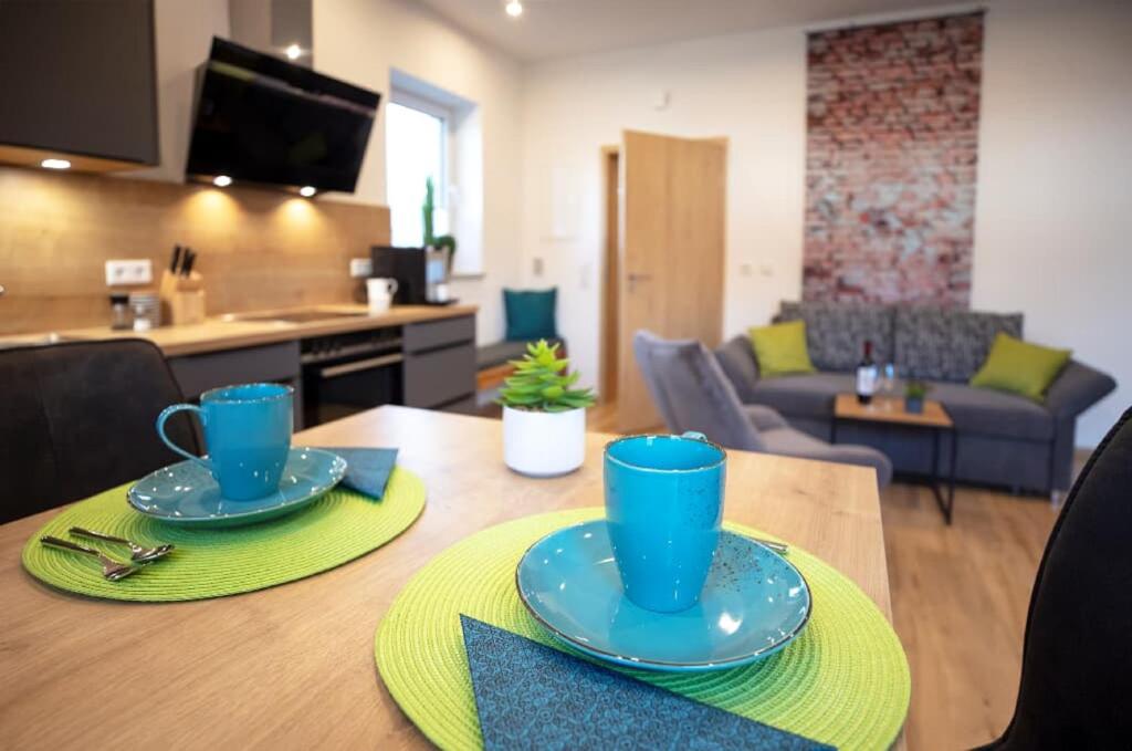 una mesa de comedor con platos azules encima en Ferienwohnung Kiesenberg 9, en Thanstein