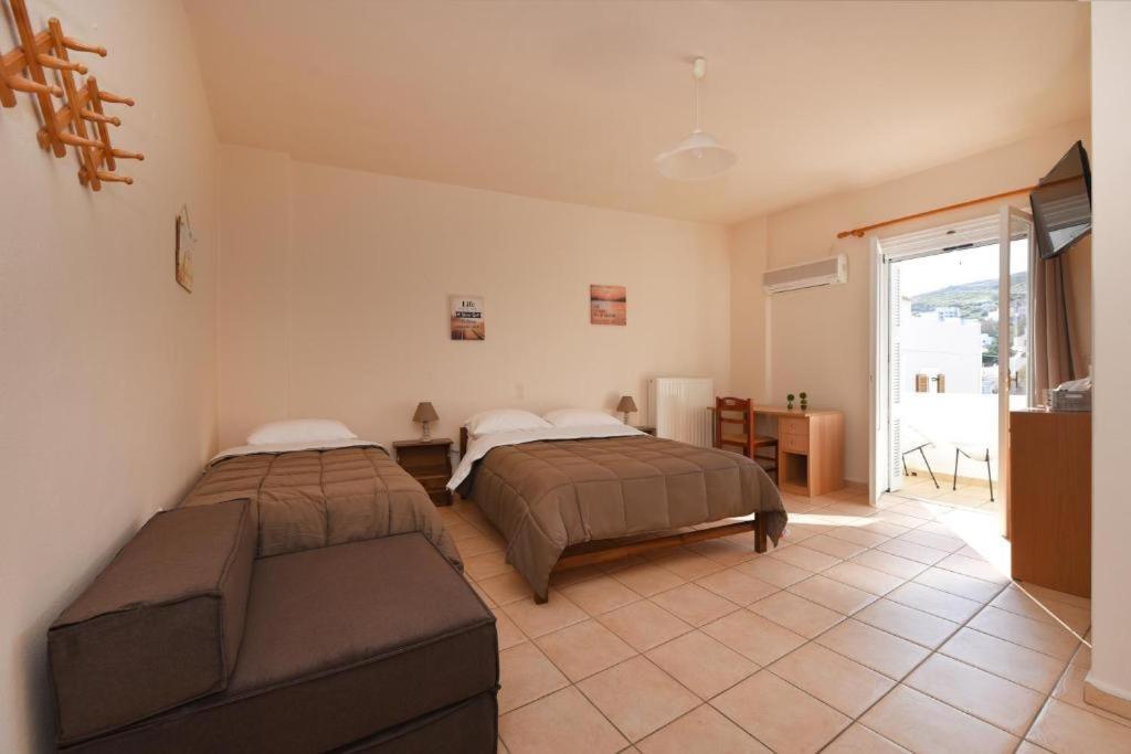 a bedroom with two beds and a couch at CENTRAL APARTMENTs in Ermoupoli