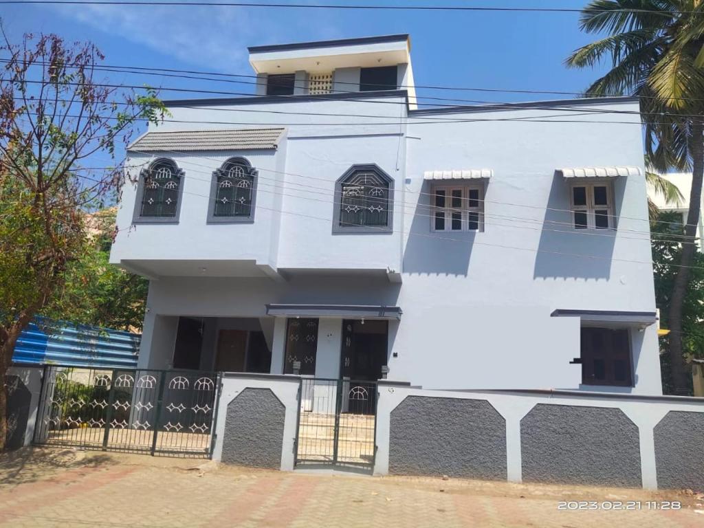 a white house with a fence in front of it at Le Grace Eden in Madurai