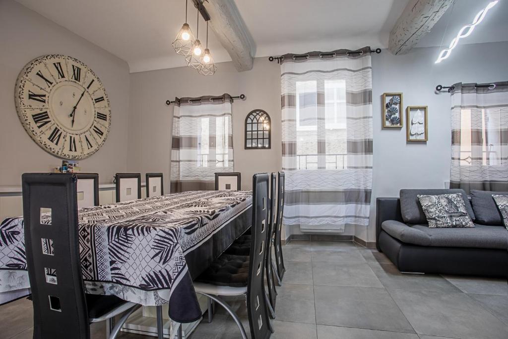 une salle à manger avec une table et une grande horloge dans l'établissement Maison de village Carcès, à Carcès