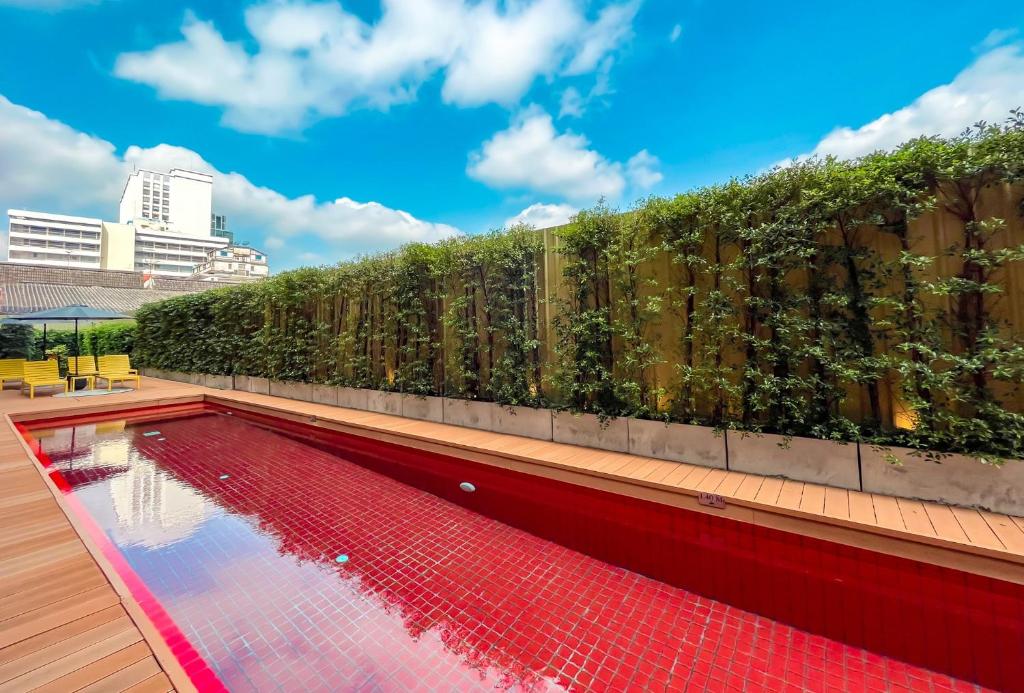 a swimming pool with a hedge on a fence at The Iconic Hotel Ari - Jatujak in Bangkok