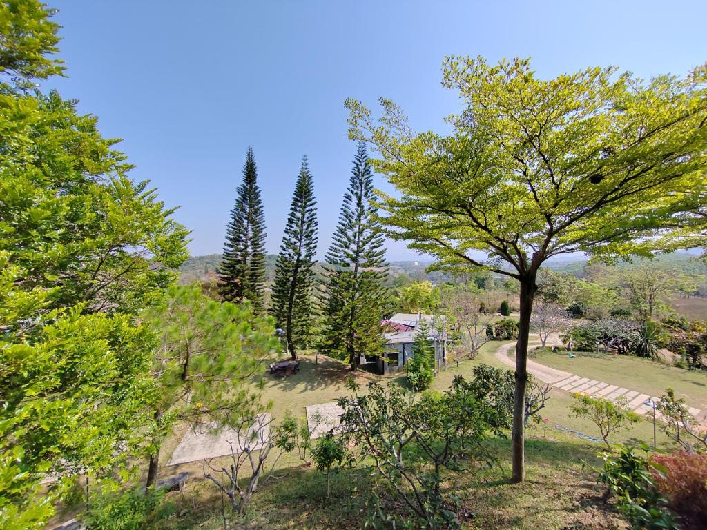 uitzicht op een park met bomen en een huis bij Baan Suan Plearndara in Wang Nam Khieo