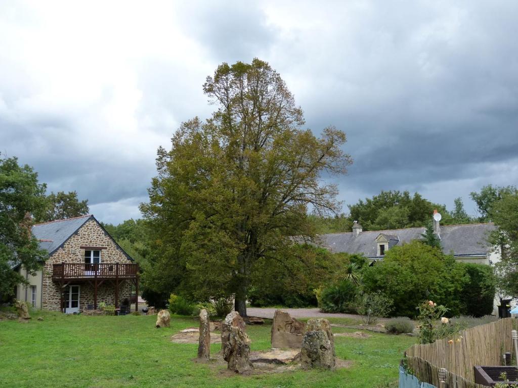 una casa con un patio con lápidas y un árbol en ROCHE-LOIRE, en Le Thoureil