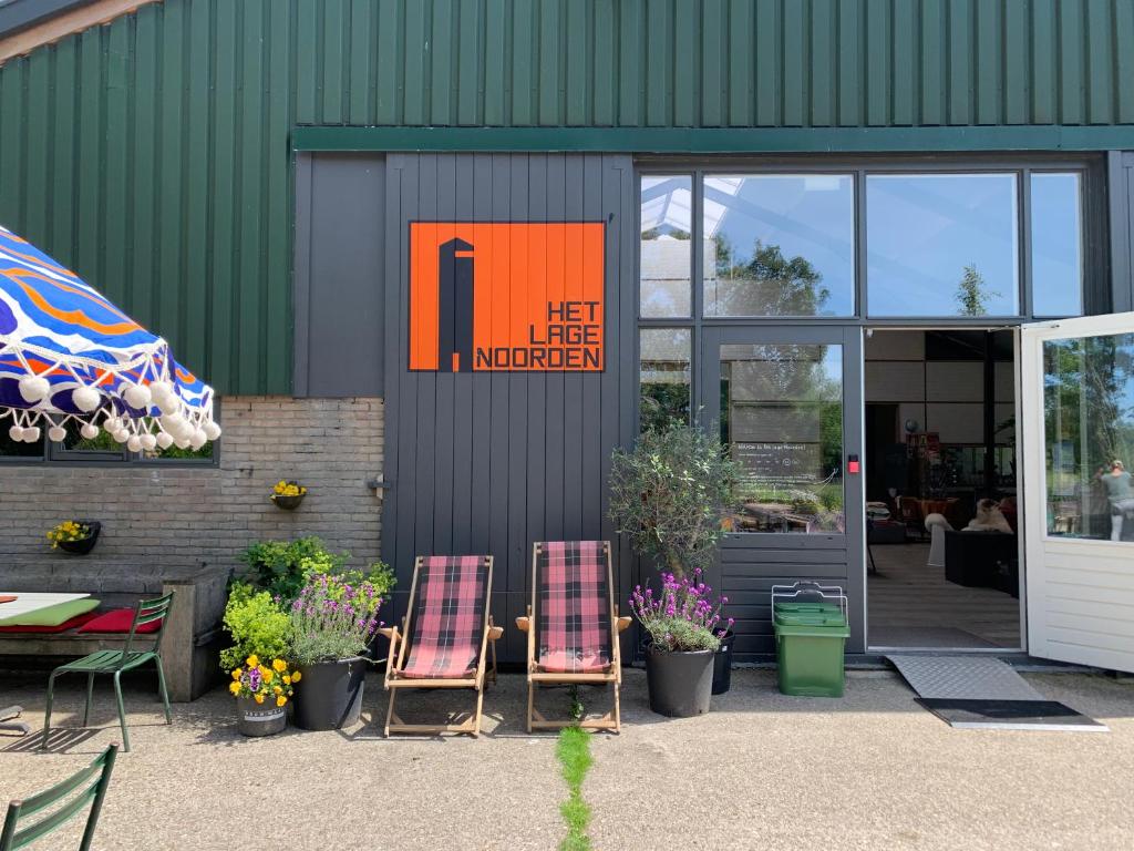 een paar stoelen voor een gebouw bij Het Lage Noorden in Marrum