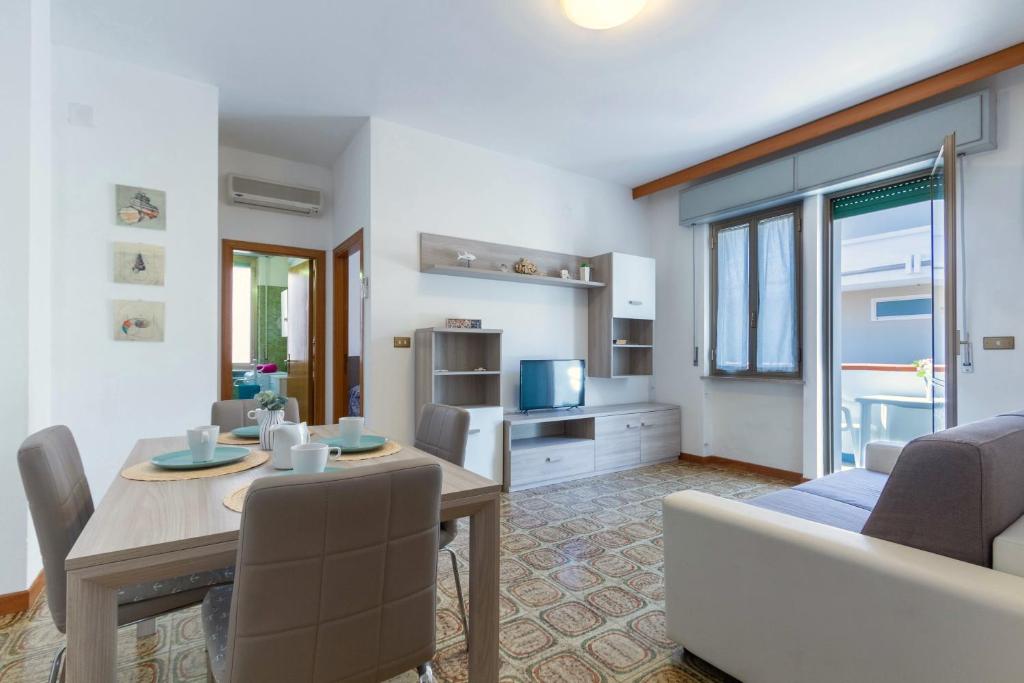 een woonkamer met een tafel en een eetkamer bij Appartamento Vespucci Bilo - MyHo Casa in Tortoreto Lido