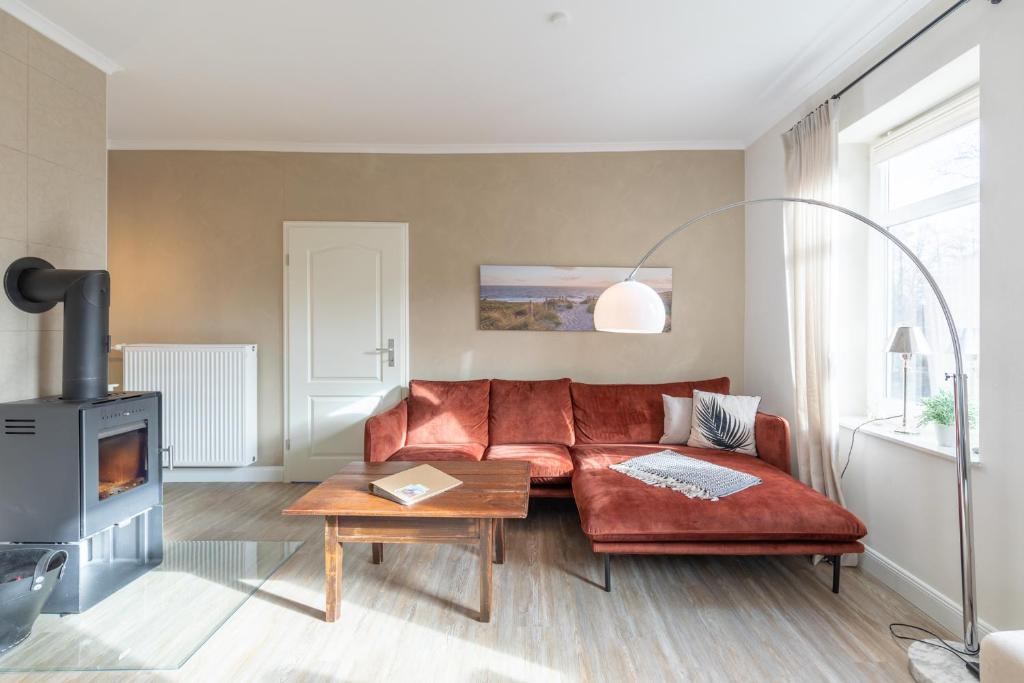- un salon avec un canapé rouge et une cheminée dans l'établissement Alte Wassermuehle Hollebek, à Bredstedt