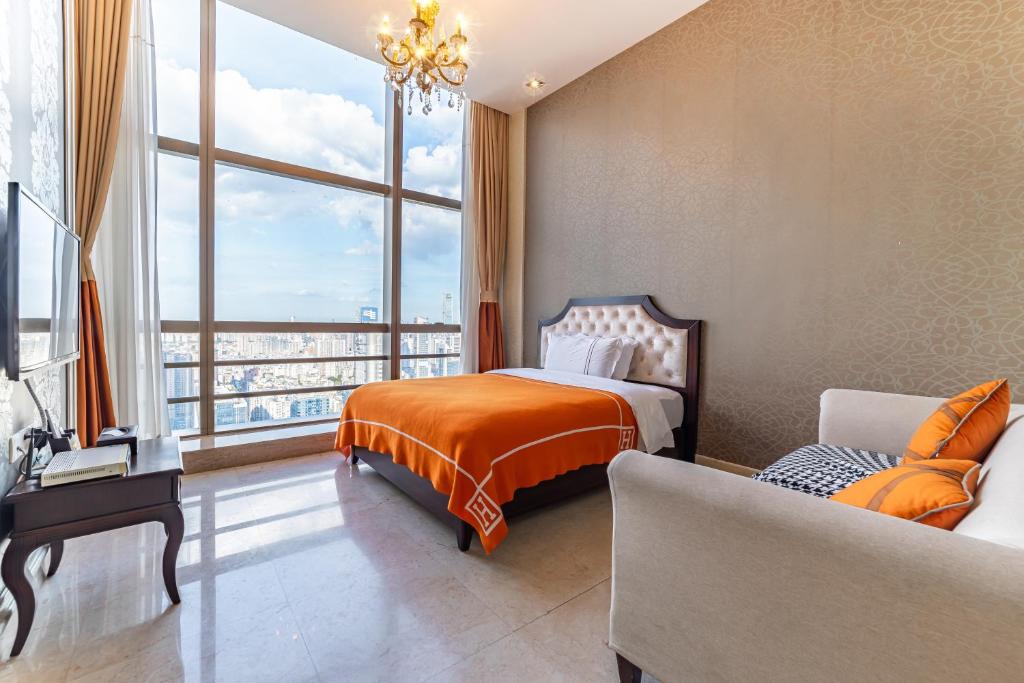 a bedroom with a bed and a couch and a large window at WAIFIDEN Guangzhou Grand View Golden Palace Apartment - Free shuttle bus during the Canton Fair in Guangzhou