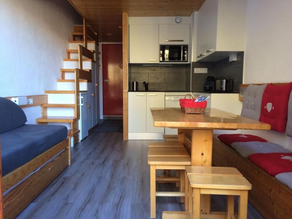 een kleine keuken met een tafel en een bank in een kamer bij Arcs 1800 Duplex rénové 5 pers au pied des pistes calme location à la semaine seulement in Arc 1800