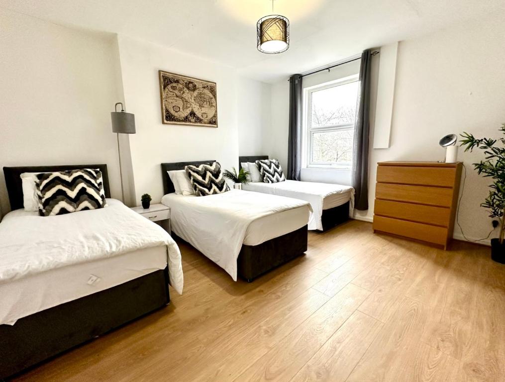 a bedroom with two beds and a window at Beautiful 3-Bed Apartment with Driveway Parking in Nottingham