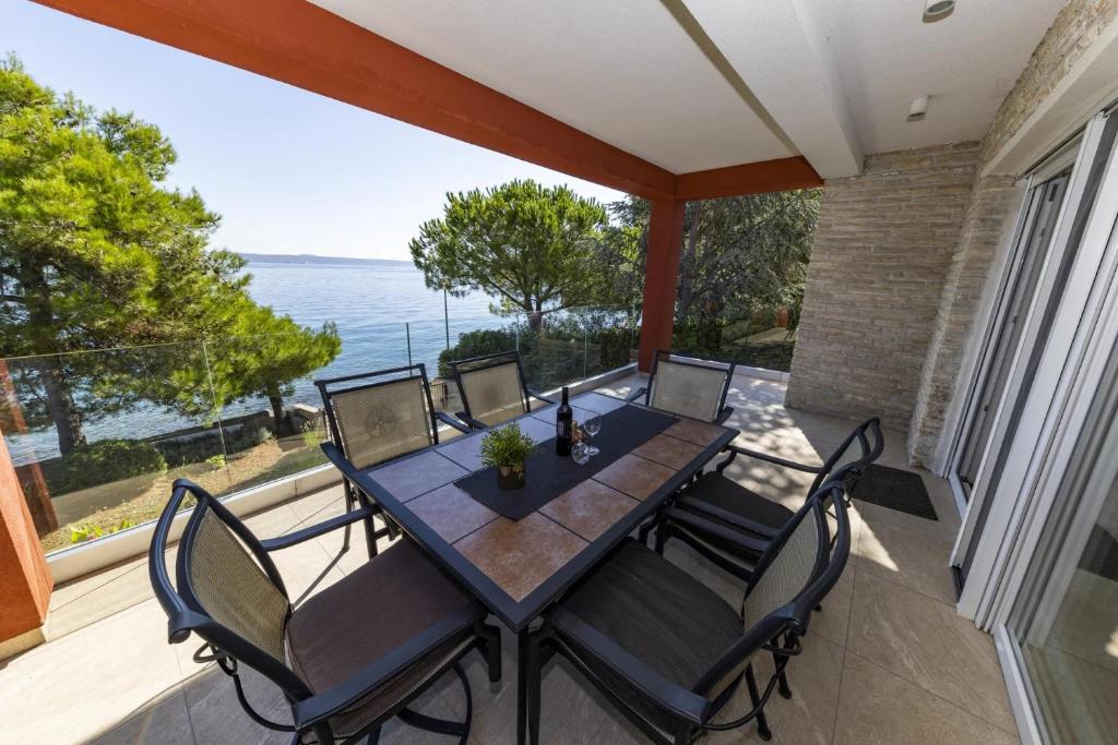 a patio with a table and chairs on a balcony at Villa Karmen Adriatica in Kukljica
