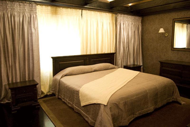 um quarto com uma cama grande e uma janela em Gogol Hotel em Myrhorod