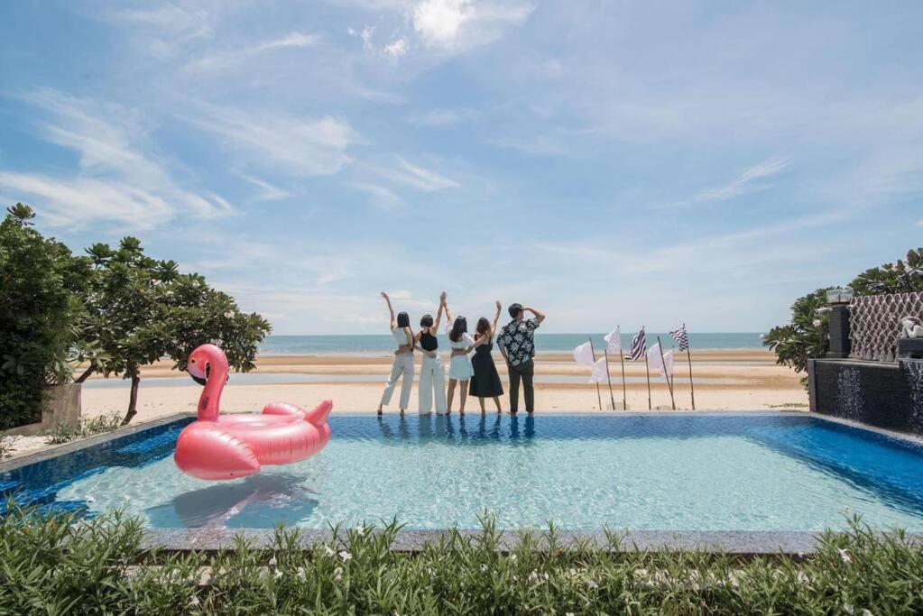 a group of people standing in a pool with a pink swan at Angel Stay Pool Villa Pranburi บ้านพักปราณบุรี พูลวิลล่าปราณบุรี ติดทะเล in Ban Pru Yai
