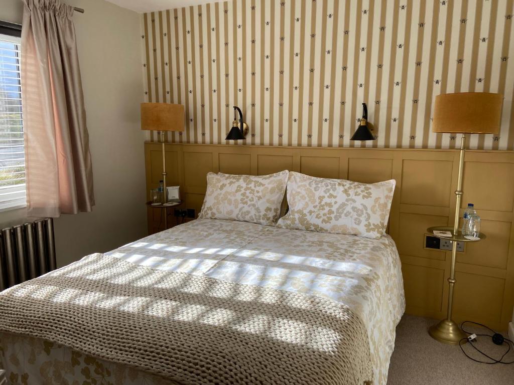 a bedroom with a bed and a striped wall at Dewcroft in Horsley