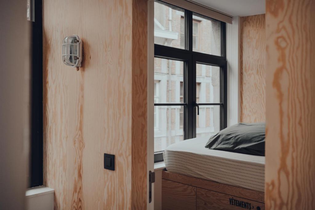 a bedroom with a bed and a window at Cabane Urbaine 1 - centre in Namur