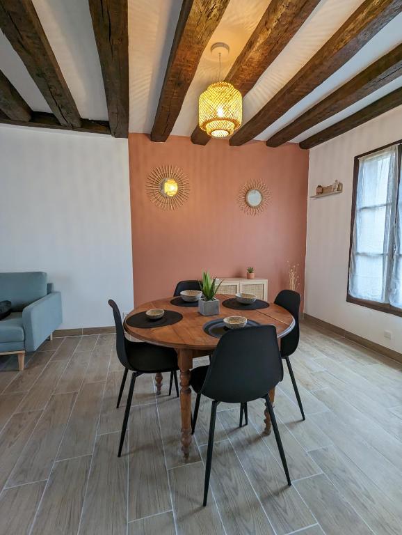une salle à manger avec une table et des chaises en bois dans l'établissement La Petite Chaume, à Châteauroux