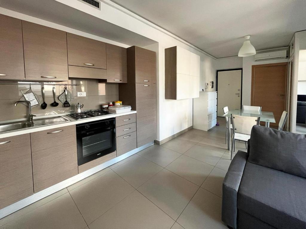 a kitchen and living room with a couch and a table at Sebeto Apartment in Naples