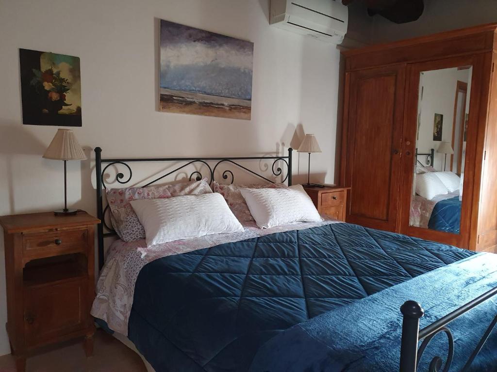 a bedroom with a bed with a blue comforter at Bed & Breakfast Belfiore in Lonato del Garda