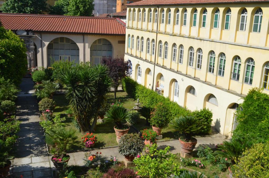 a courtyard of a building with potted plants at Casa per ferie religiosa Figlie di Nazareth in Pisa
