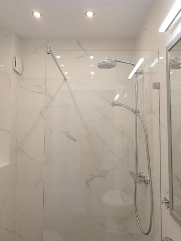 Un baño con ducha con puerta de cristal. en Duplex 250 m from Market Square, en Wroclaw