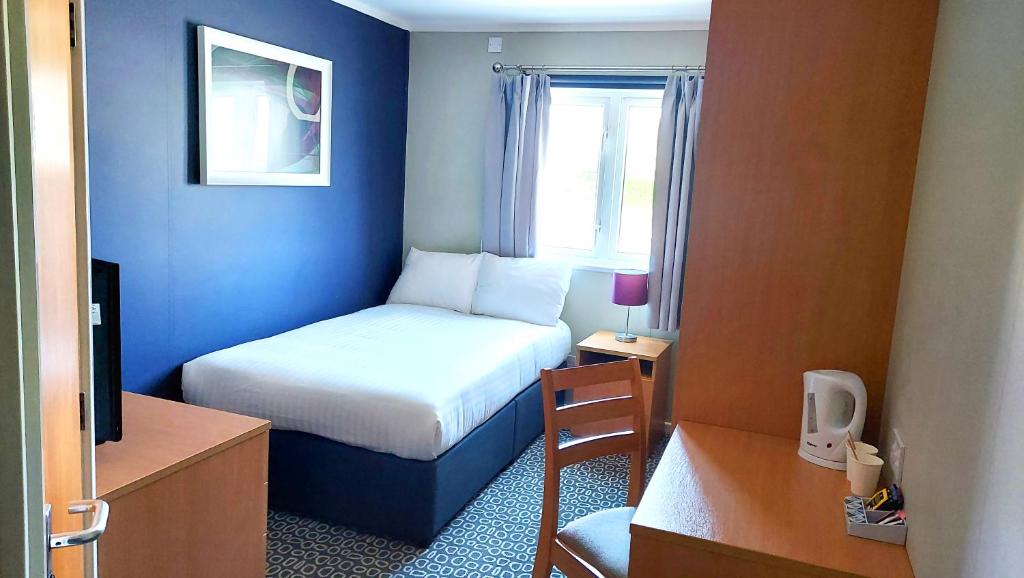 um quarto de hotel com uma cama e uma janela em Nightel Hotel em Kirmington