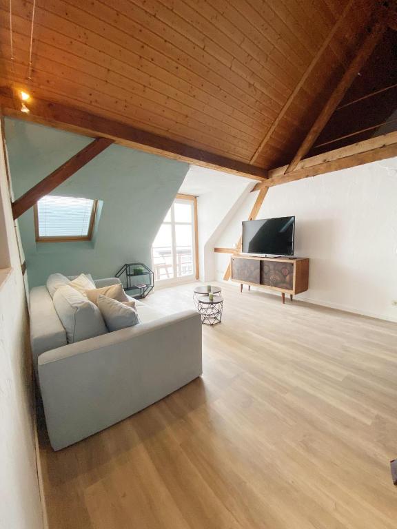 a living room with a white couch and a television at Ferienwohnungen Annweiler am Trifels in Annweiler am Trifels