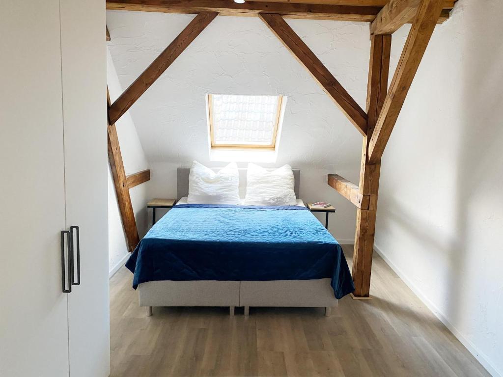 - une chambre mansardée avec un lit bleu dans l'établissement Ferienwohnungen Annweiler am Trifels, à Annweiler am Trifels