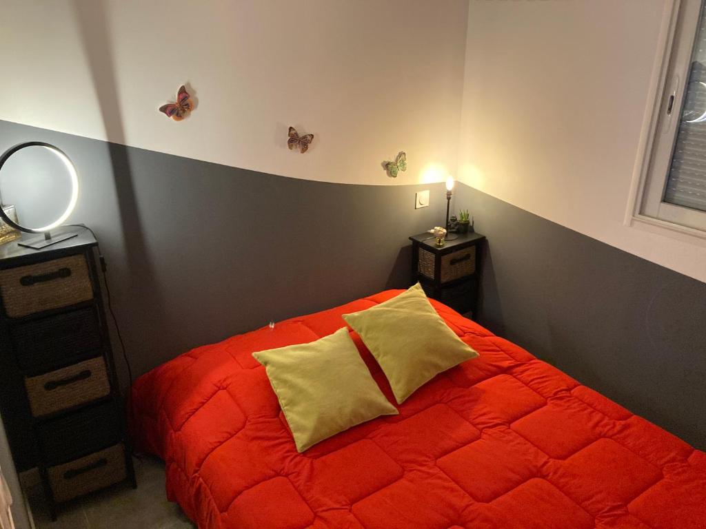 a bedroom with a red bed with two yellow pillows at B&amp;B Macchia Verdata avec piscine in Monacia-dʼAullène