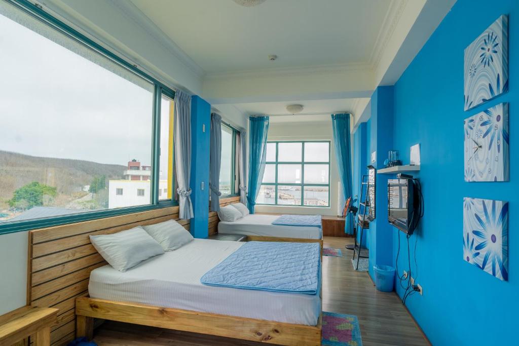 Habitación con 2 camas y ventana en Meet Bay B&B, en Xiyu