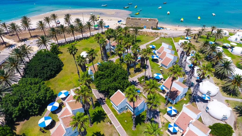 an aerial view of a resort with palm trees and a beach at Dor Country Lodging in Dor