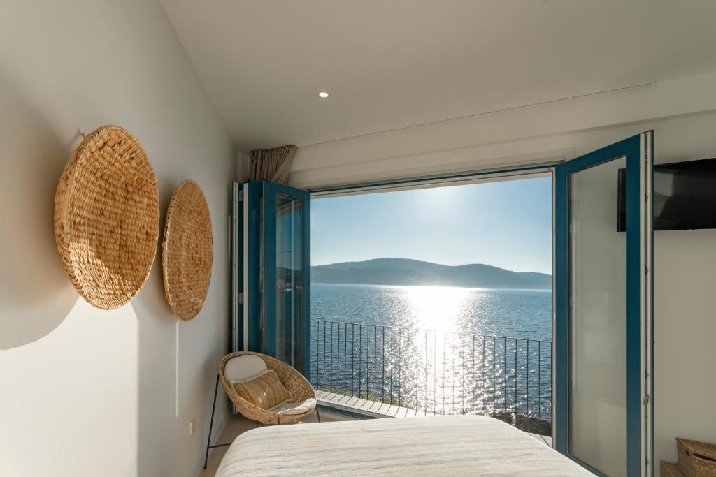 a bedroom with a view of the ocean at O mar de preciosa in Camariñas