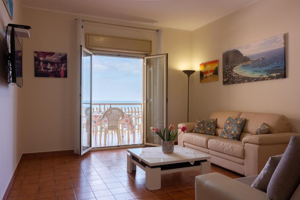 un soggiorno con divano, tavolo e finestra di casavacanzabordonaro a Palermo