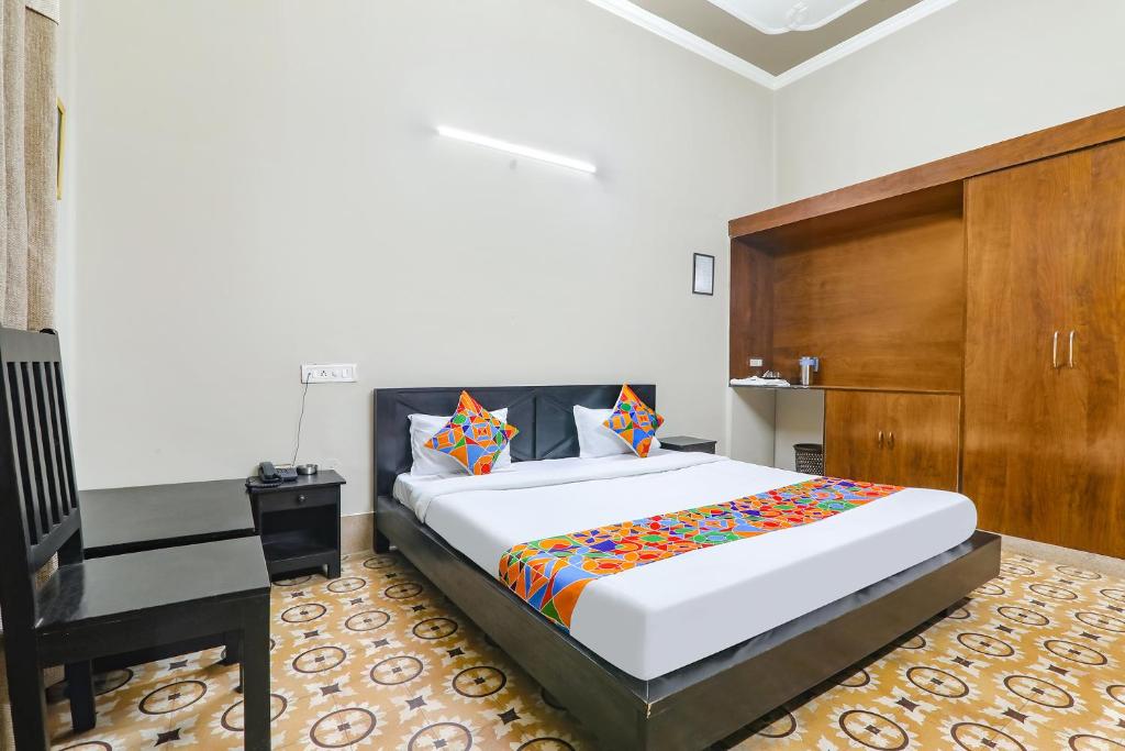 a bedroom with a large bed and a wooden cabinet at FabHotel Harmony in Colonelganj