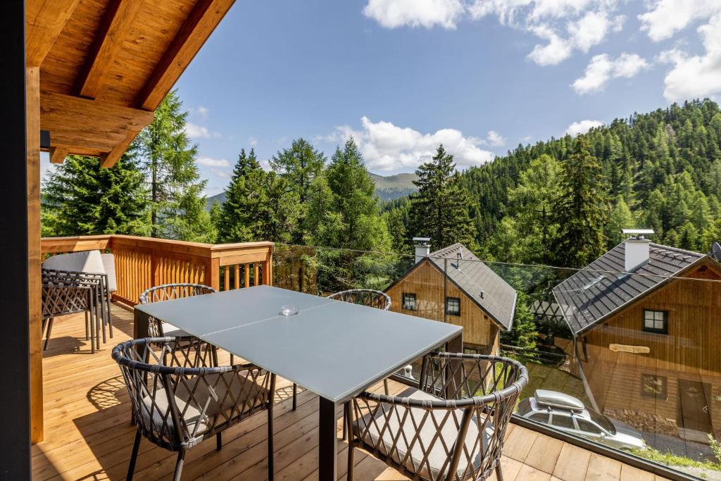 eine Terrasse mit einem Tisch und Stühlen auf einer Terrasse in der Unterkunft Turrach Lodges by ALPS RESORTS in Turracher Hohe
